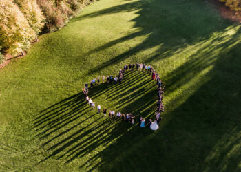 Wedding guests lined up in the shape of heart with bride and groom marriage people