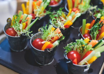 Beautifully decorated catering banquet table with variety of vegetables and different vegan vegetarian snacks on corporate christmas birthday party event or wedding celebration